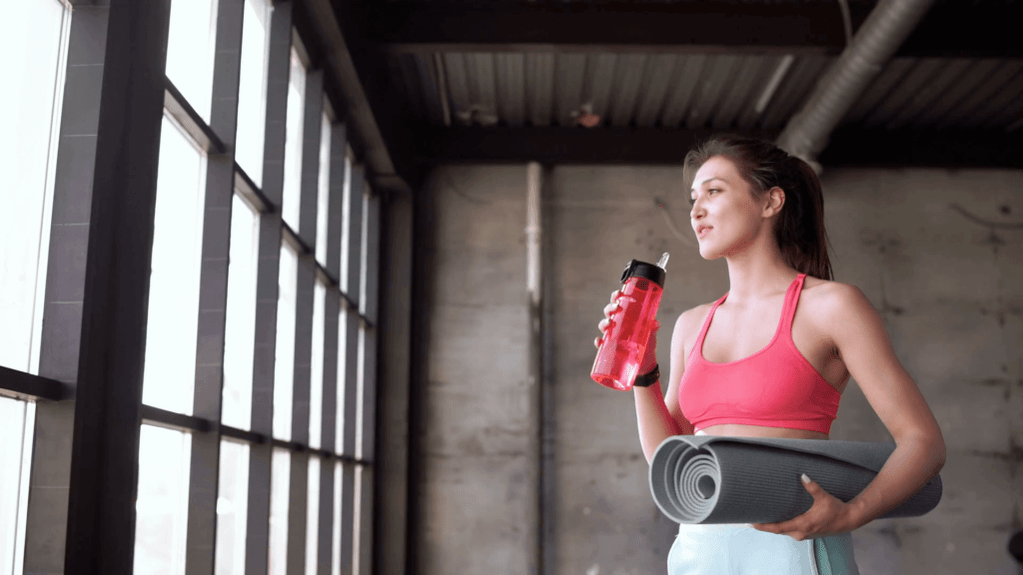 Das Mädchen steckt eine Flasche Wasser und Teppich